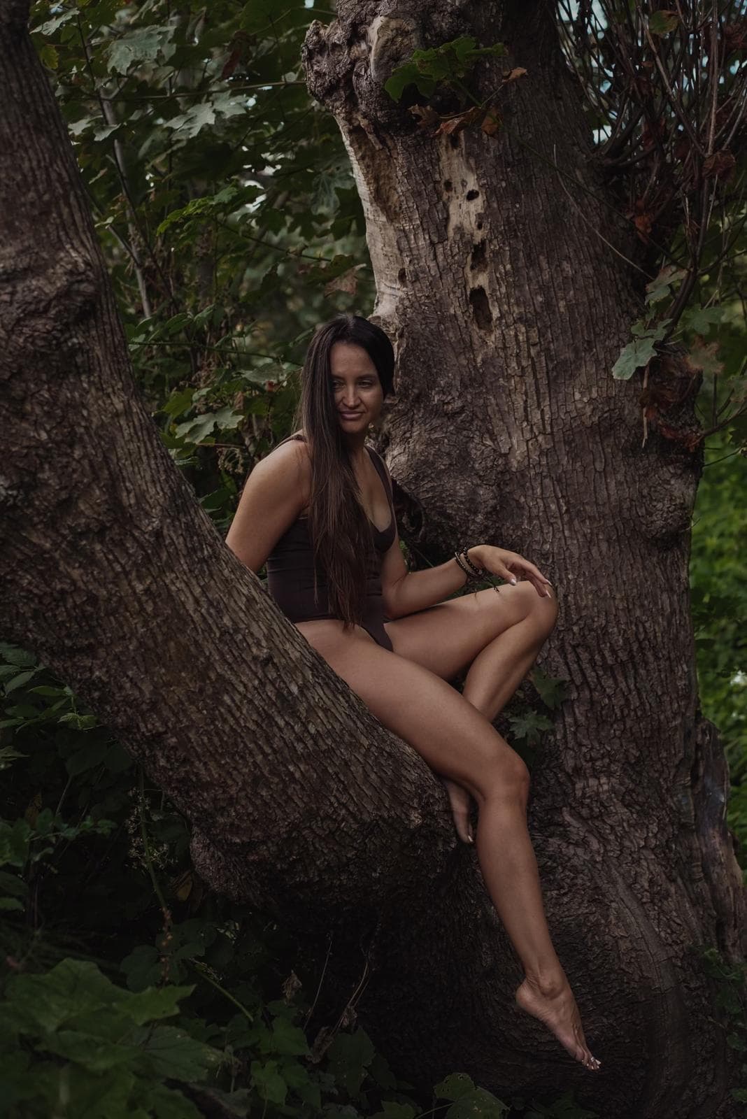 Oxana Kirsanova resting in the boughs of an old tree